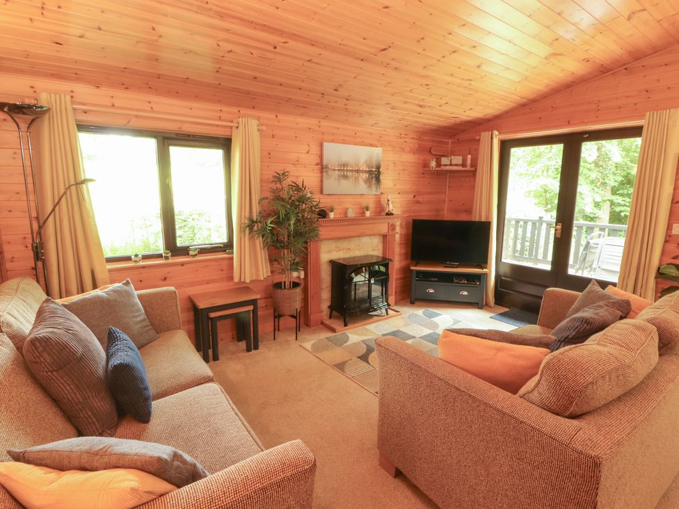 A living room with a sofa and television at Derwent Lodge in Keswick