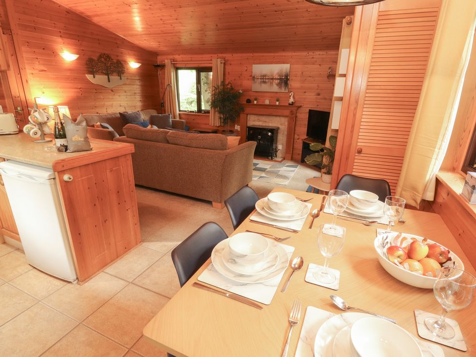 A living room with a sofa and dining table at Derwent Lodge in Keswick
