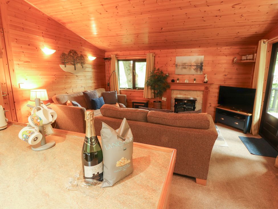 A living room with a sofa and television at Derwent Lodge in Keswick