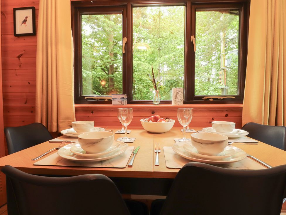 A dining room with a table set for meals at Derwent Lodge in Keswick