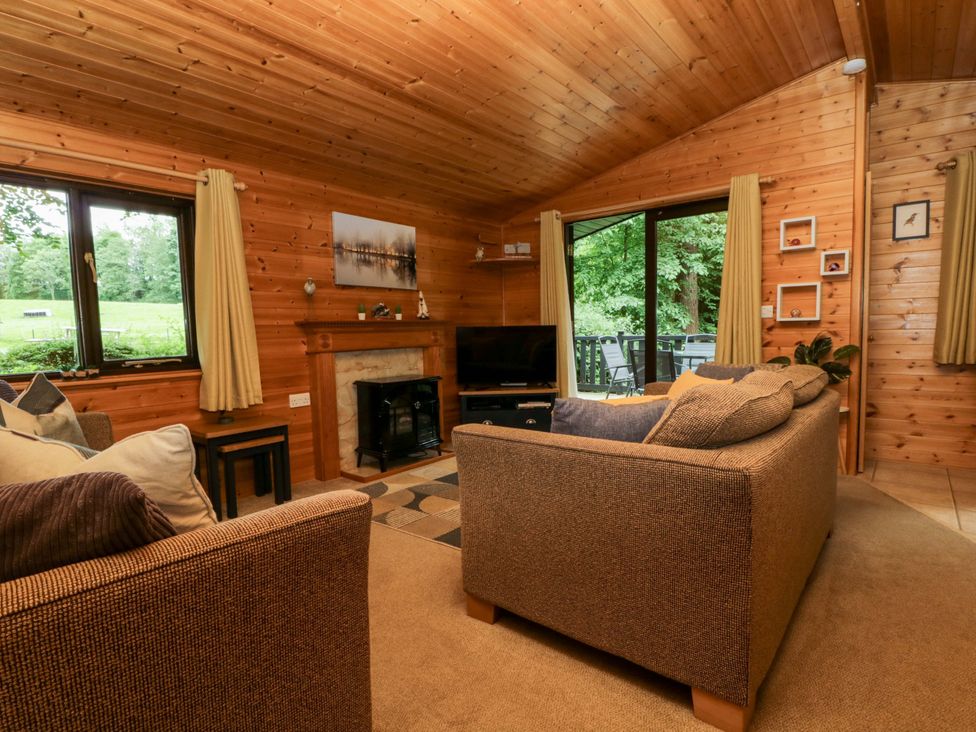 A living room with a television and sofa at Derwent Lodge in Keswick