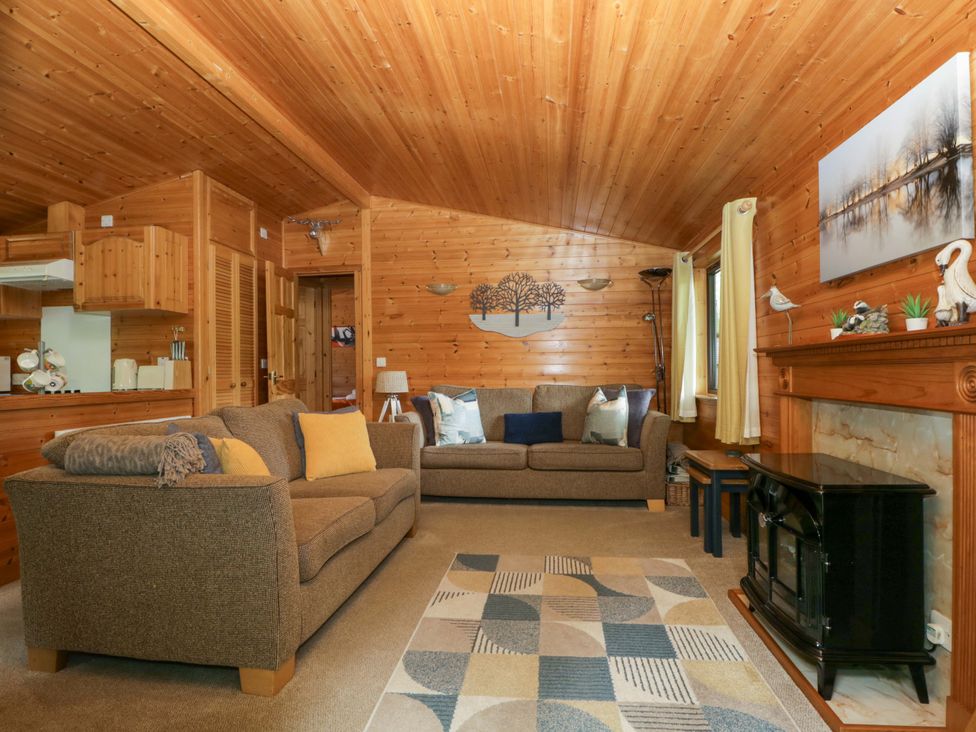 A living room with a sofa and fireplace at Derwent Lodge in Keswick