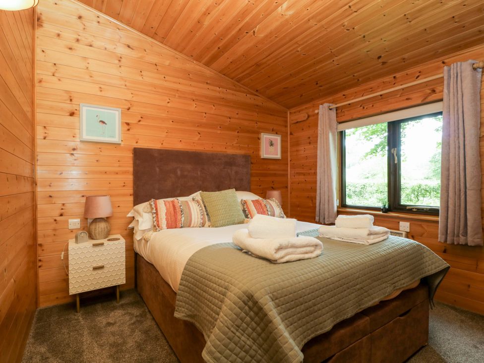 A bedroom with a bed and bedside table at Derwent Lodge in Keswick
