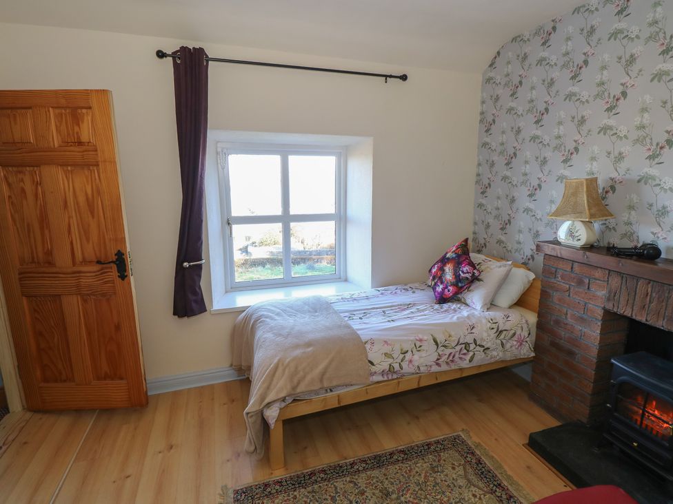 A bedroom with a bed and a fireplace at Sea View House Tully, County Galway