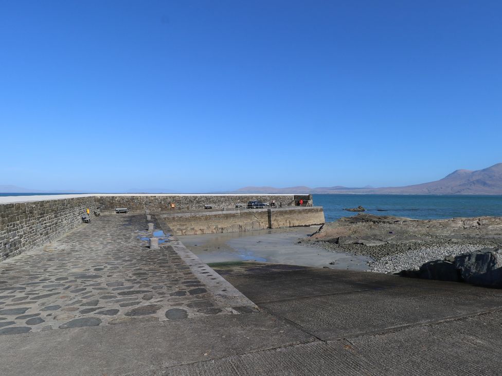 A view of a pier with benches by the water at Sea View House in Tully, County Galway