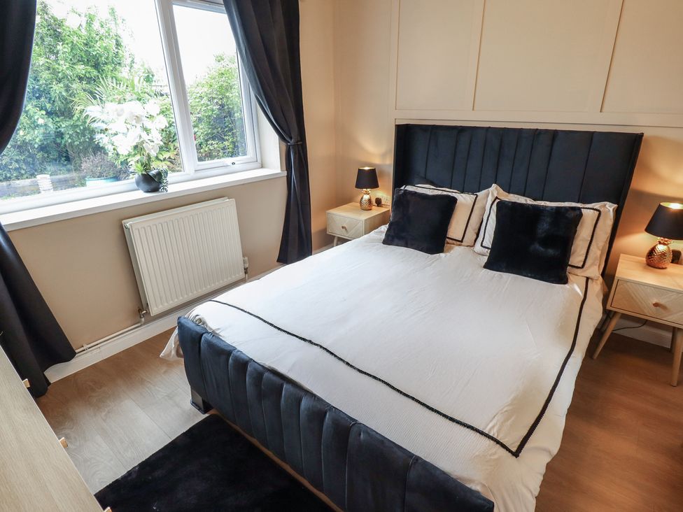 A bedroom with a bed and bedside tables at Mariai Eton Road Trusthorpe