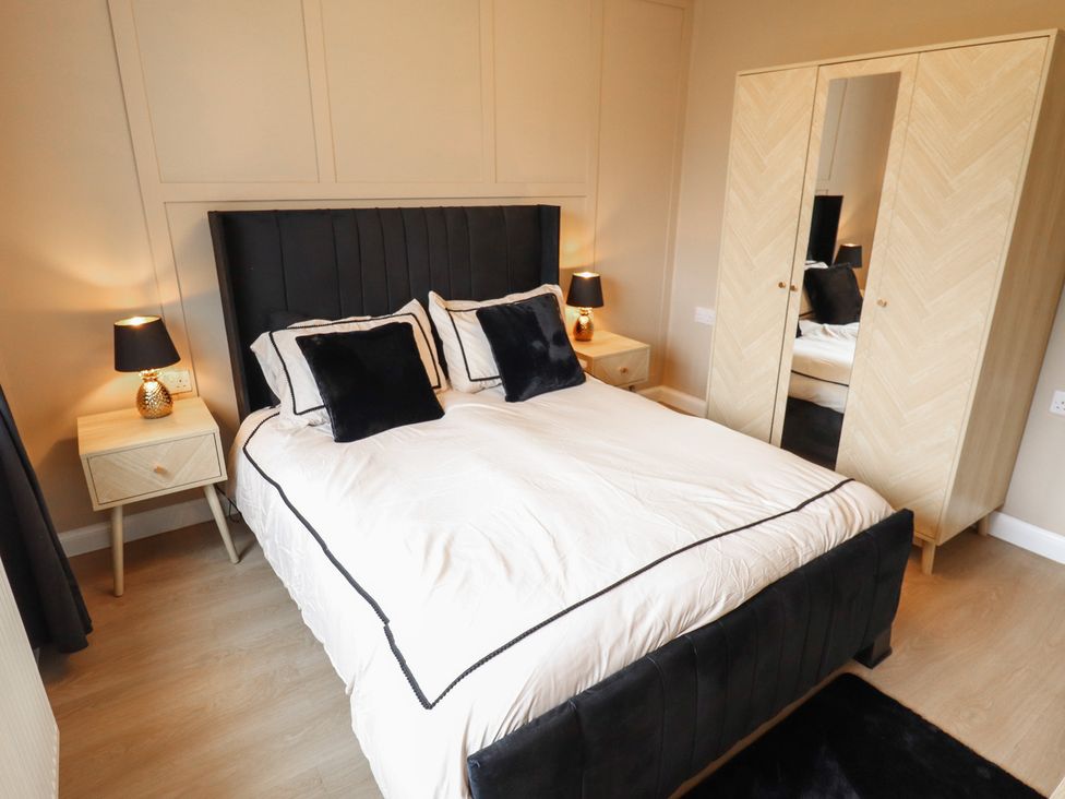 A bedroom with a bed and bedside table at Mariai Eton Road in Trusthorpe