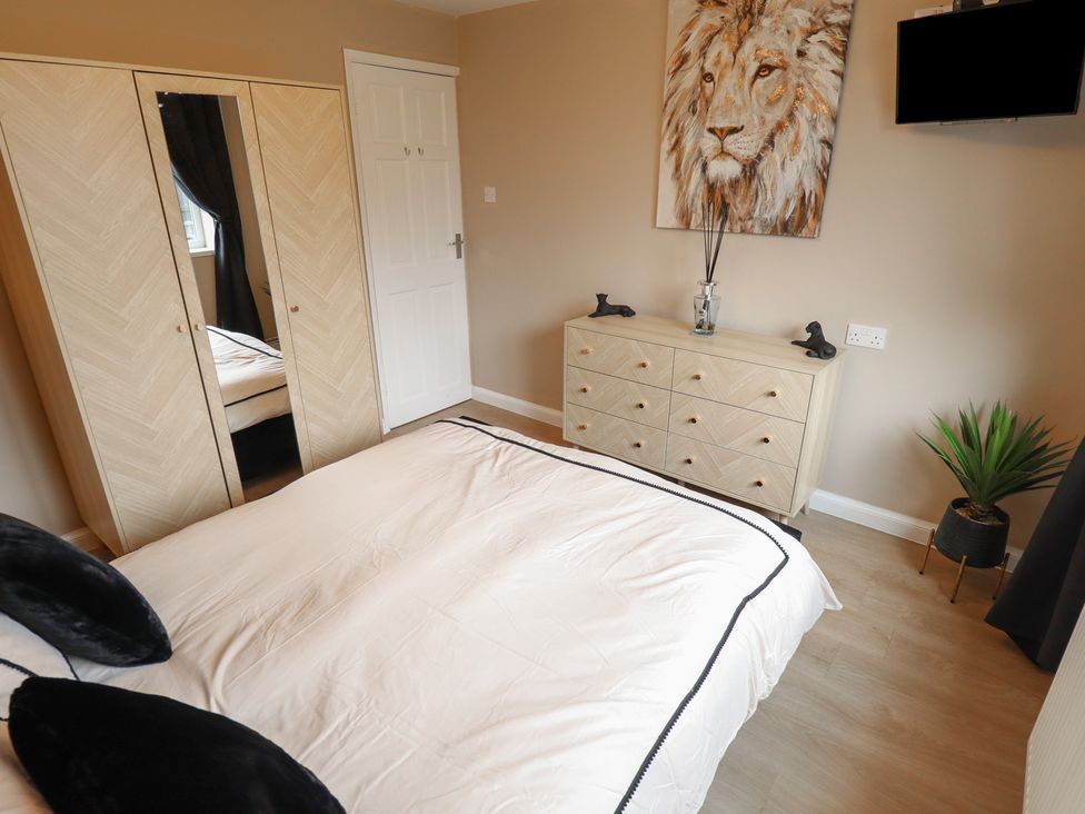 A bedroom with a bed, wardrobe, dresser and television at Mariai Eton Road, Trusthorpe
