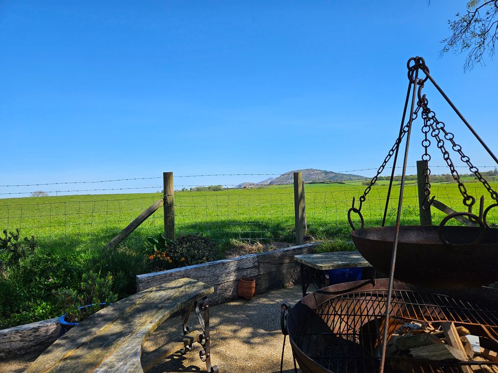 An outdoor area with a fire pit and view of a field at The Keepers Lodge in Boduan near Nefyn