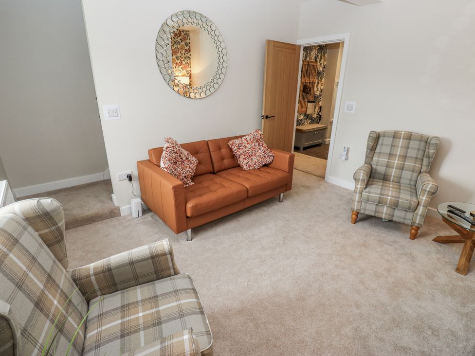 A living room with a sofa and armchairs at Millside View