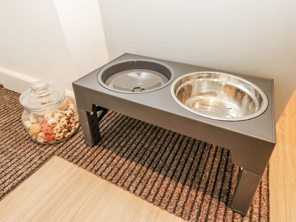 A pet food bowl stand with a glass jar of treats at Millside View