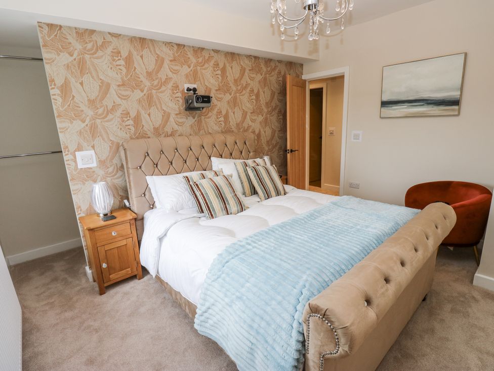 A bedroom with a bed and a chair at Millside View 