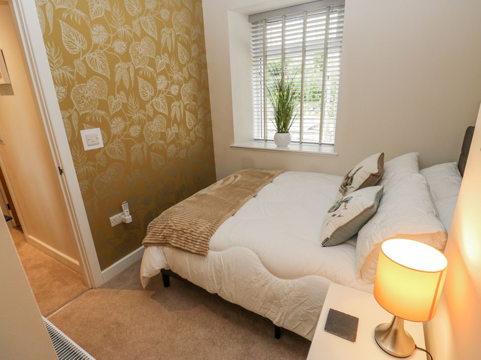 A bedroom with a bed and a plant at Millside View 