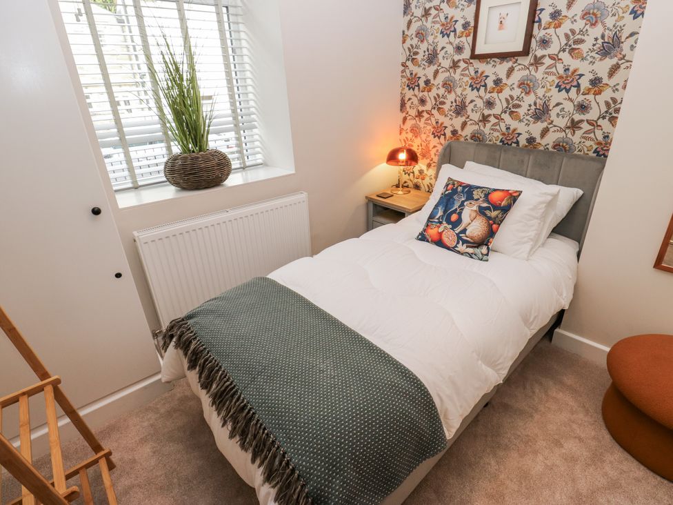 A bedroom with a bed and lamp at Millside View