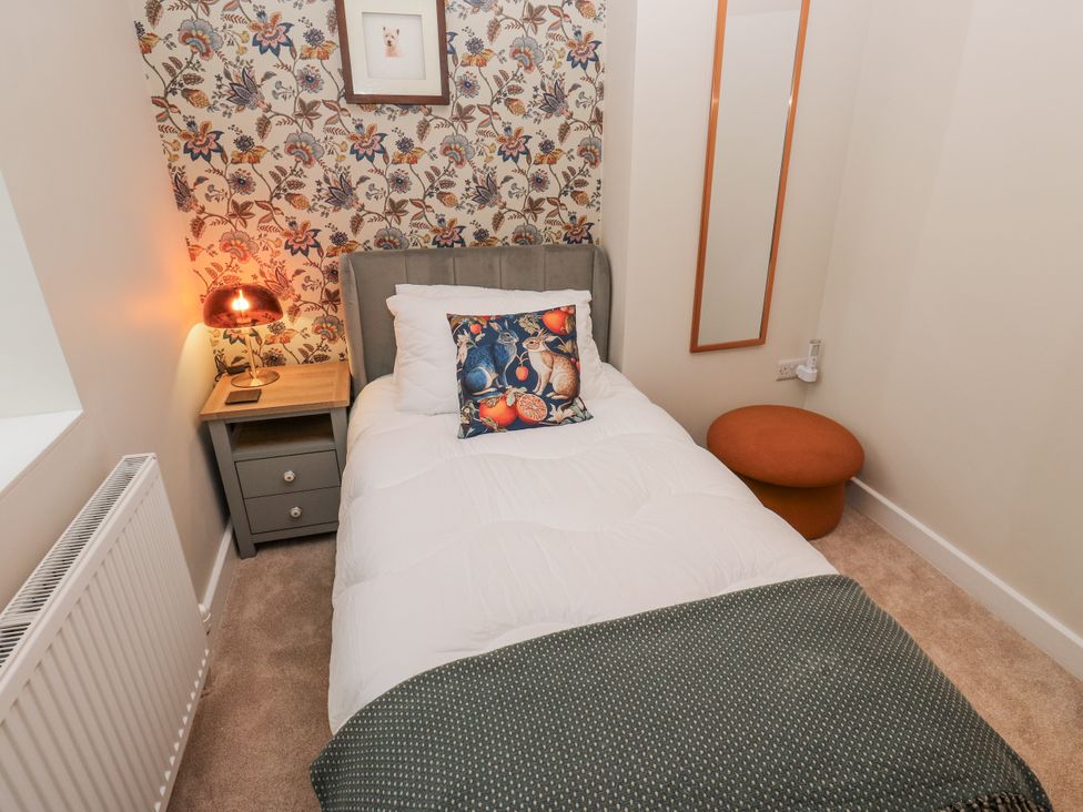 A bedroom with a single bed and bedside table at Millside View