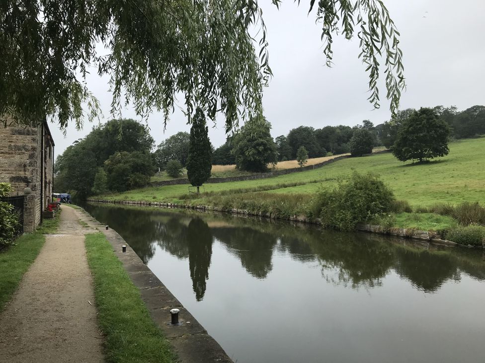 A path alongside a river with trees at Millside View in Kildwick