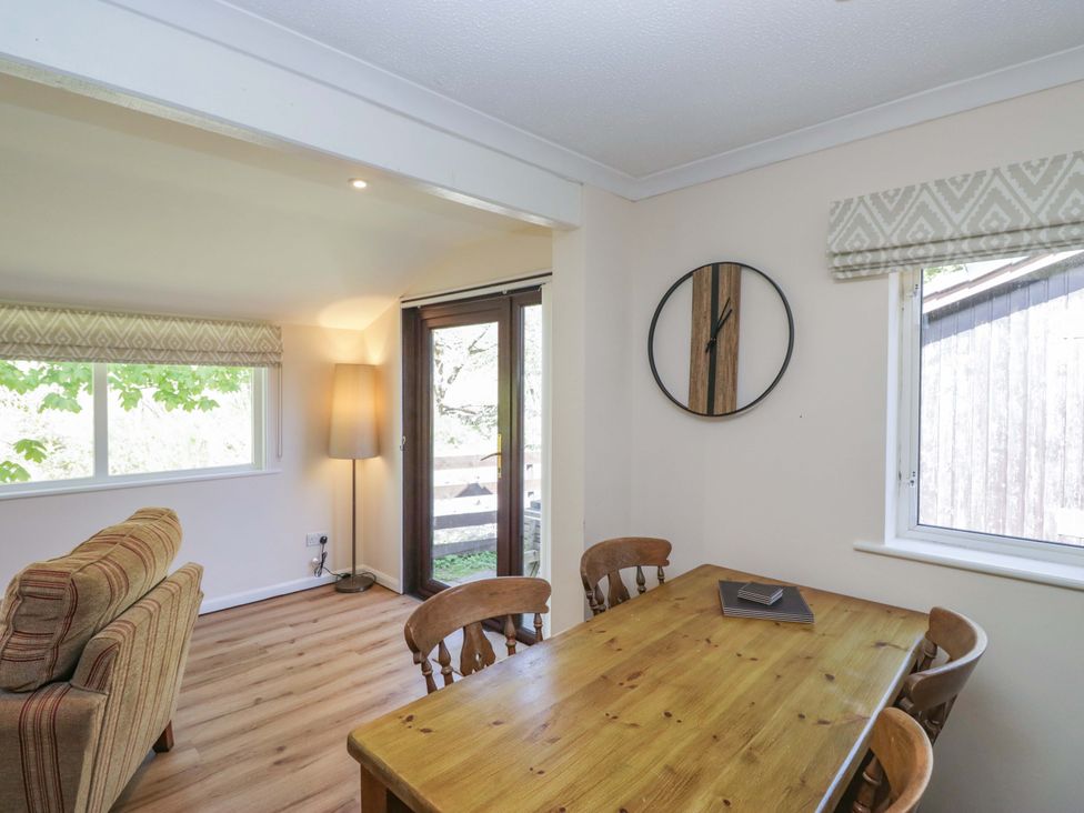 A dining room with a table and chairs at Chestnut Timber Lodge in Keswick