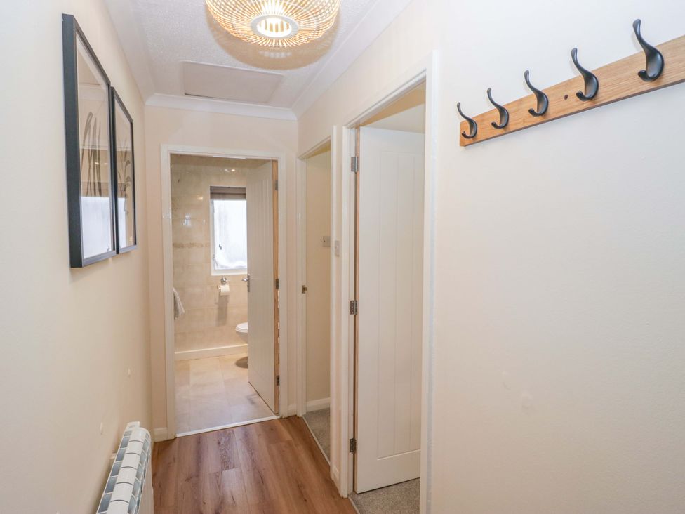 A hallway with coat hooks and doors at Chestnut Timber Lodge in Keswick