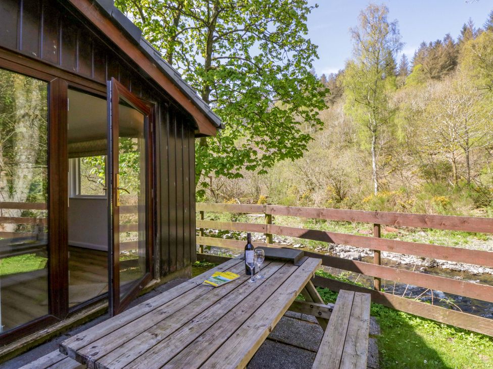 An outdoor seating area with a table and chairs at Chestnut Timber Lodge in Keswick