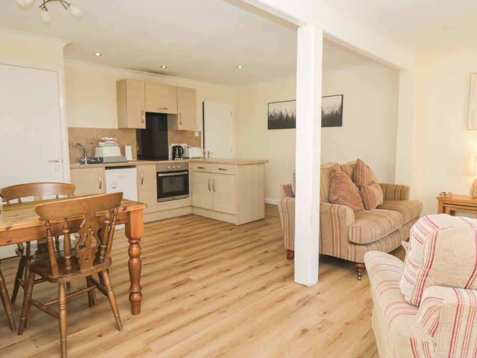 A living room with kitchen and dining area at Dogwood Timber Lodge in Keswick