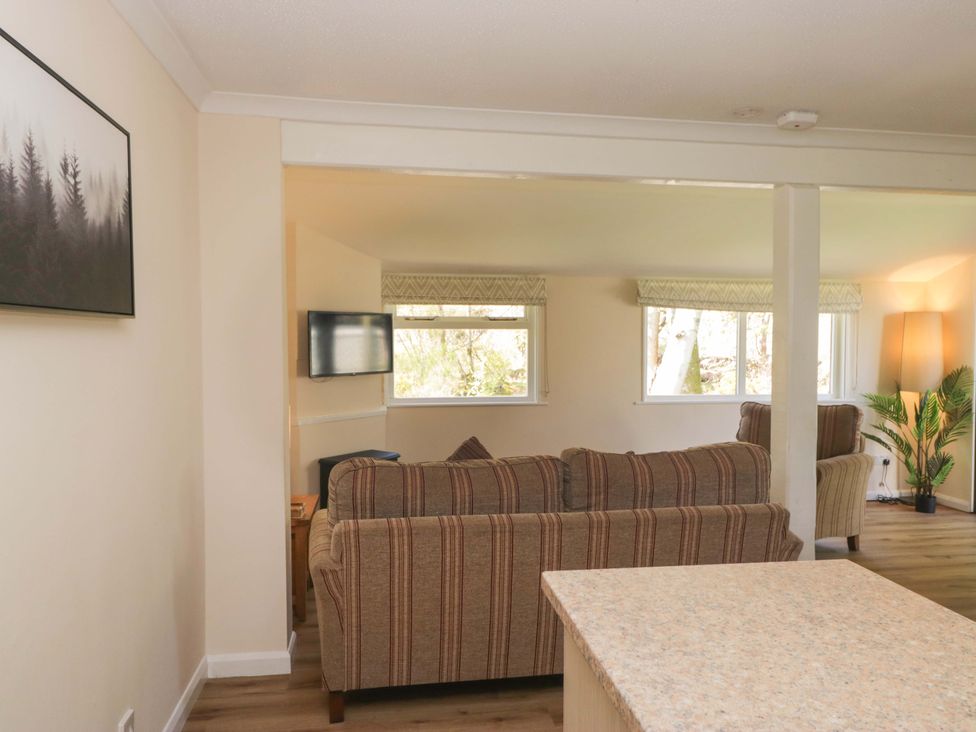 A living room with a sofa and television at Dogwood Timber Lodge in Keswick