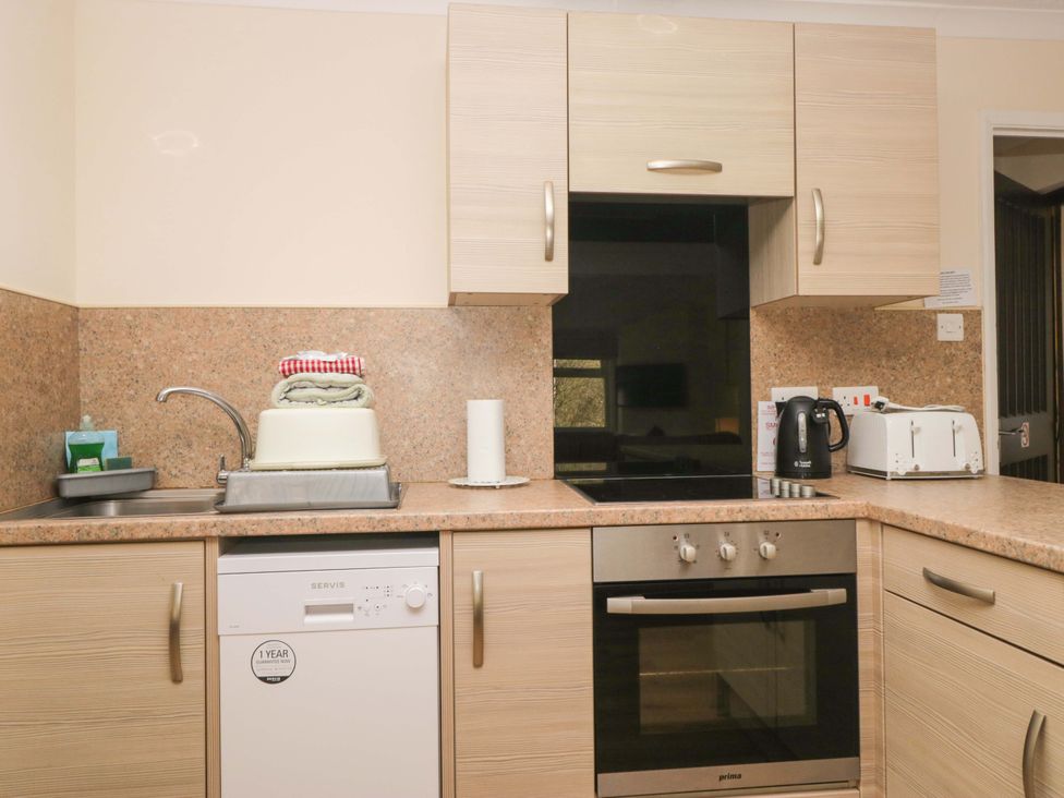 A kitchen featuring a sink, dishwasher, oven, kettle and toaster at Dogwood Timber Lodge, Keswick
