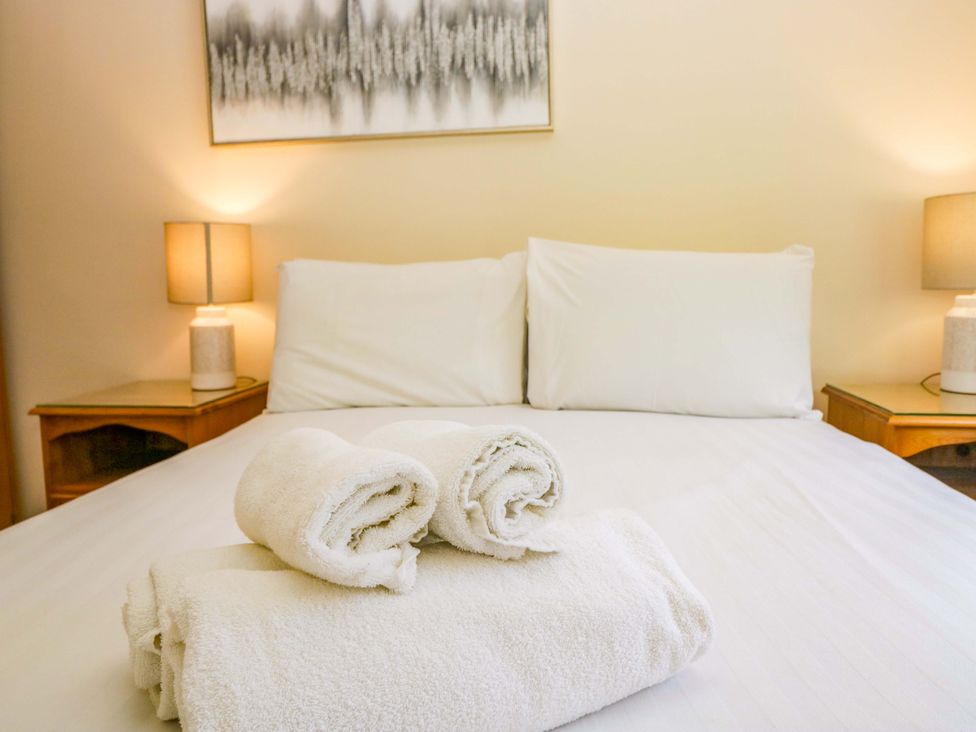 A bedroom with a bed and towels stacked at Dogwood Timber Lodge in Keswick