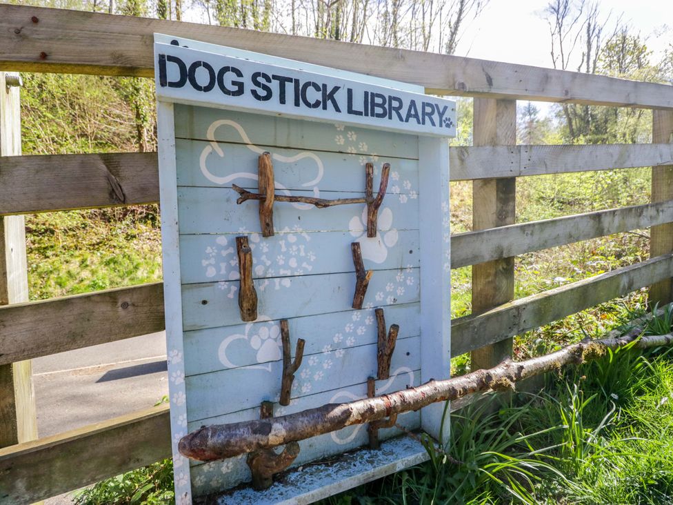 A stick library for dogs with a wooden board at Dogwood Timber Lodge in Keswick