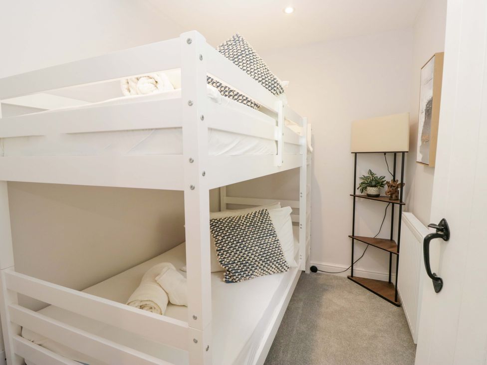 A bedroom with bunk beds and a lamp at Riverside Cottage No 4 in Keswick