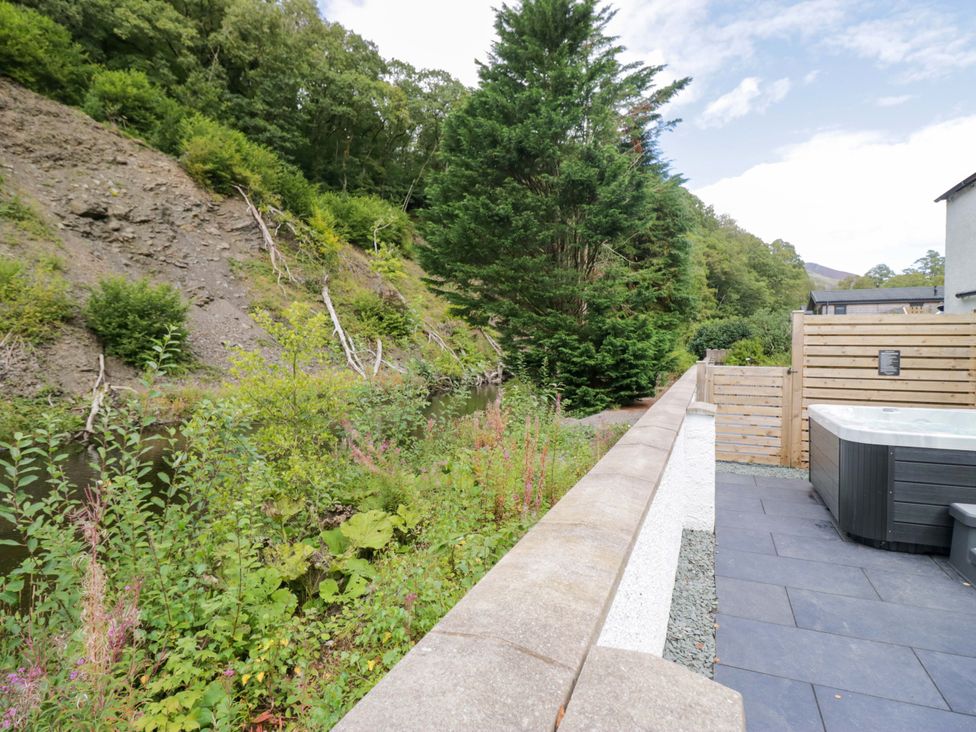 An outdoor area with a spa and trees at Riverside Cottage No 4 in Keswick