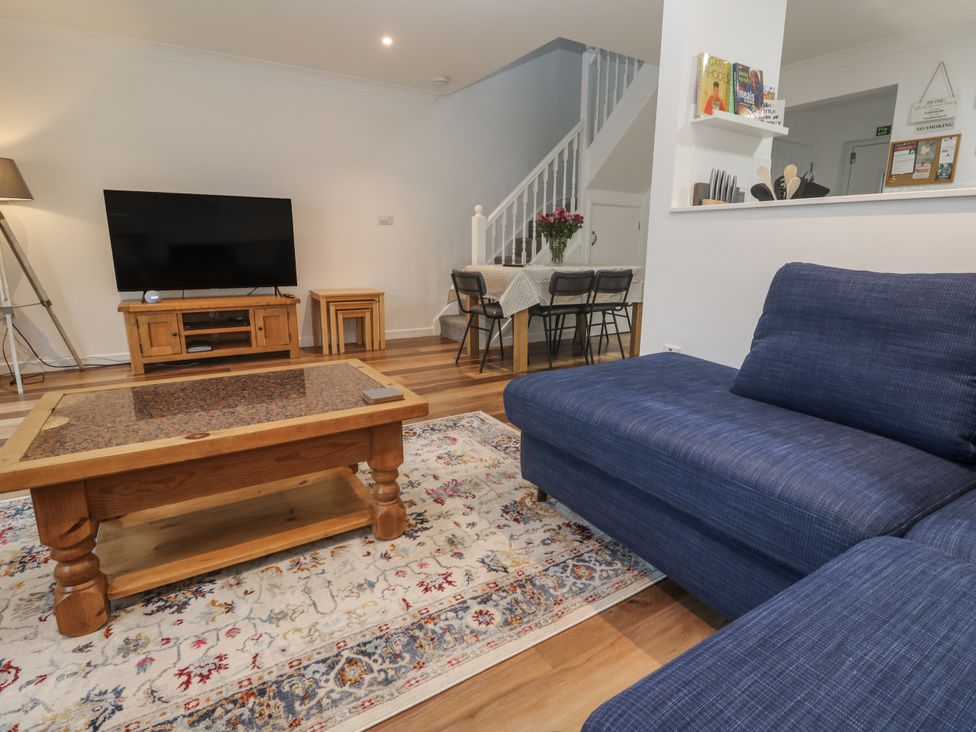 A living room with a sofa and television at Chellowdene Cottage in Falmouth