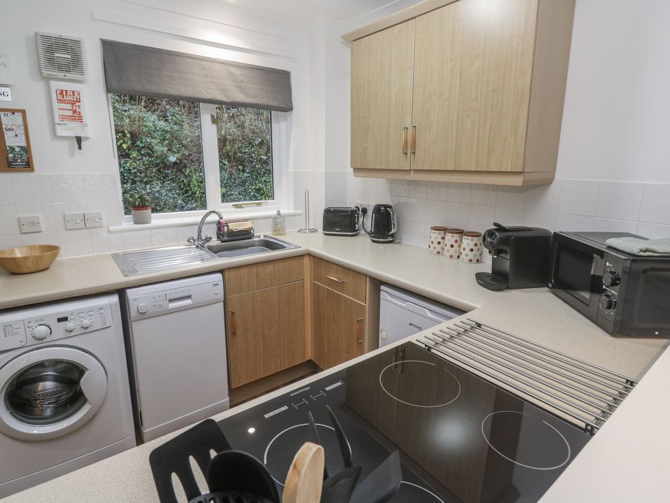 A kitchen with appliances and sink at Chellowdene Cottage in Falmouth