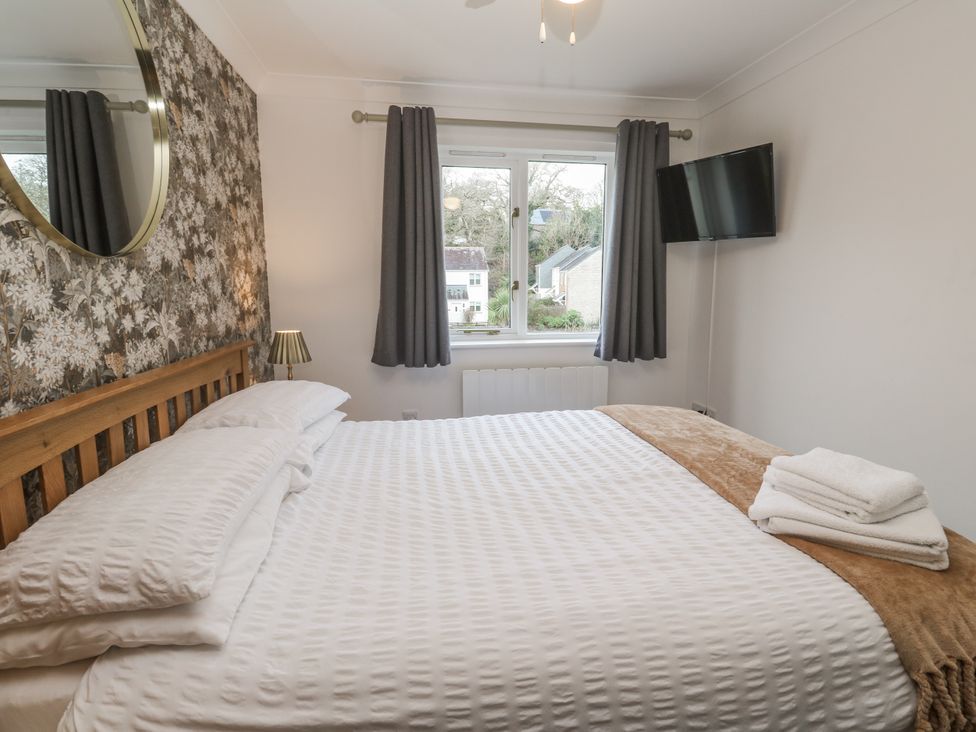 A bedroom with a bed and window at Chellowdene Cottage Falmouth