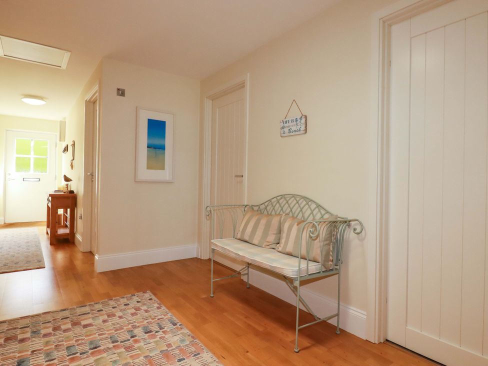 A hallway with a bench and table at Pen-Y-Les in Wadebridge