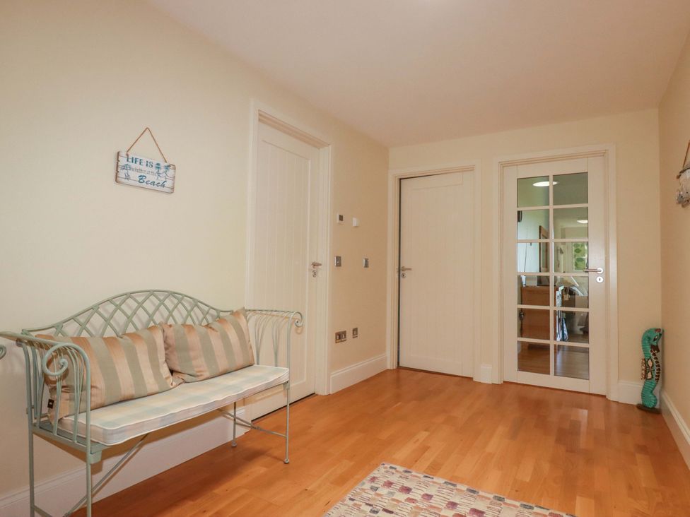 A hallway with a bench and doors at Pen-Y-Les in Wadebridge