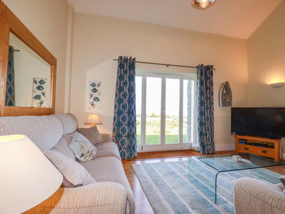 A living room with a sofa and television at Pen-Y-Les Wadebridge