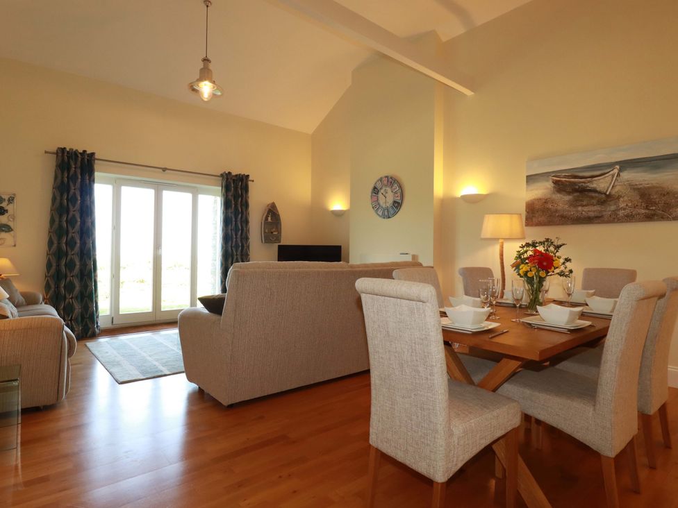 A living room with a dining area and sofa at Pen-Y-Les in Wadebridge