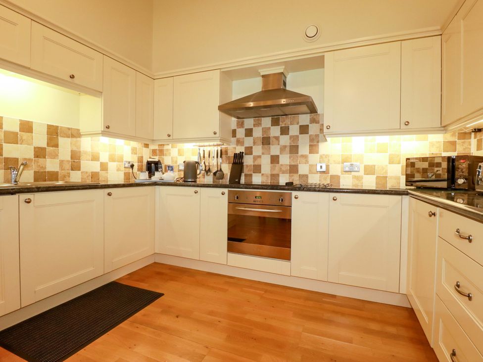A kitchen with cabinets and appliances at Pen-Y-Les in Wadebridge