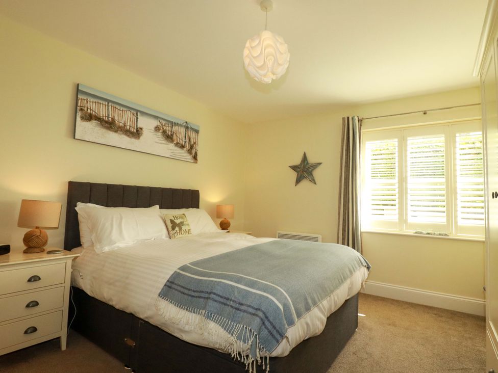 A bedroom with a bed and nightstand at Pen-Y-Les in Wadebridge