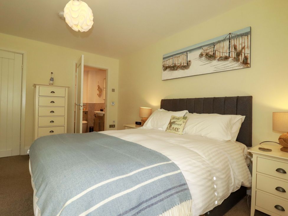 A bedroom with a bed and dresser at Pen-Y-Les in Wadebridge