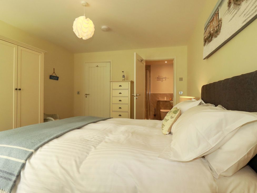 A bedroom with a bed and wardrobe at Pen-Y-Les Wadebridge