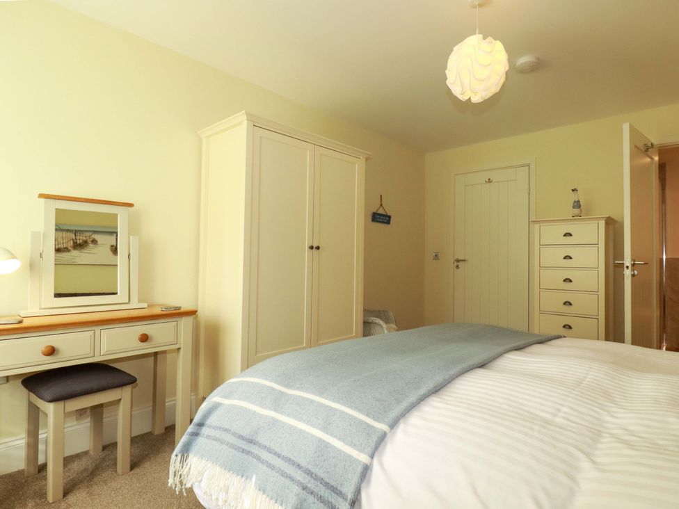 A bedroom with a bed and a desk at Pen-Y-Les in Wadebridge