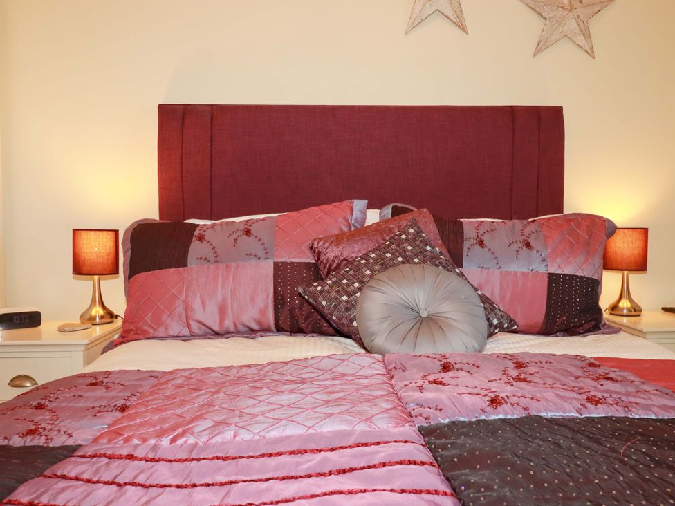 A bedroom with a bed and decorative pillows at Pen-Y-Les in Wadebridge