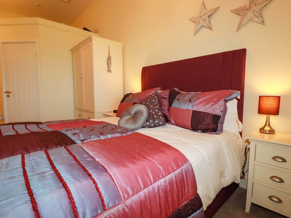 A bedroom with a bed and wardrobe at Pen-Y-Les in Wadebridge