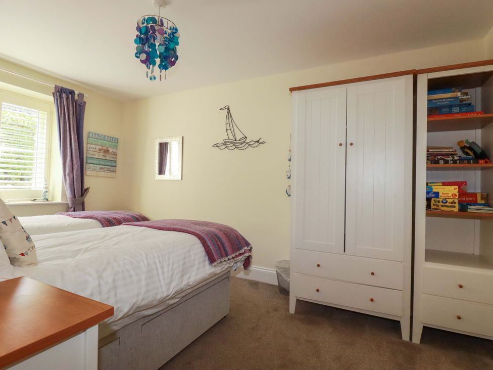 A bedroom with twin beds and a wardrobe at Pen-Y-Les in Wadebridge
