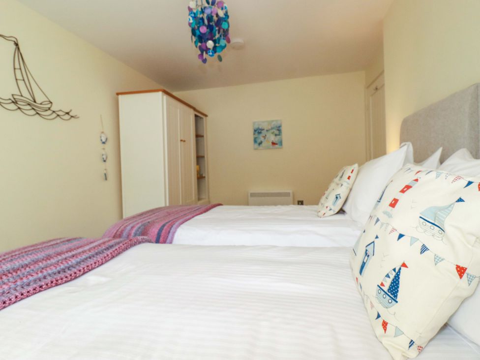 A bedroom with two beds and decorative elements at Pen-Y-Les in Wadebridge