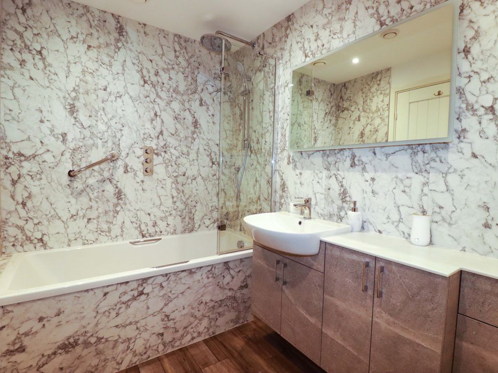 A bathroom with a bathtub and sink at Pen-Y-Les in Wadebridge