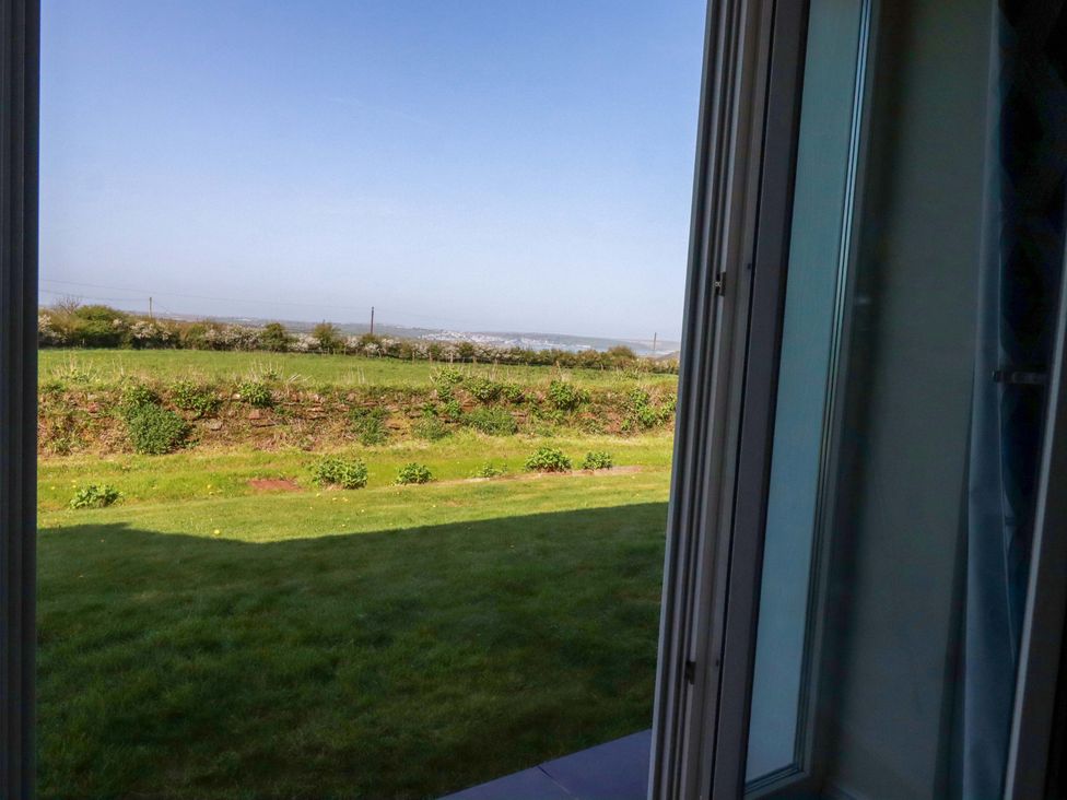 A view of grass and a distant landscape from a window at Pen-Y-Les Wadebridge