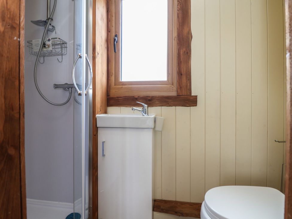 A bathroom with a shower cubicle sink with cabinet window and toilet at The Coop in Aston near Woore