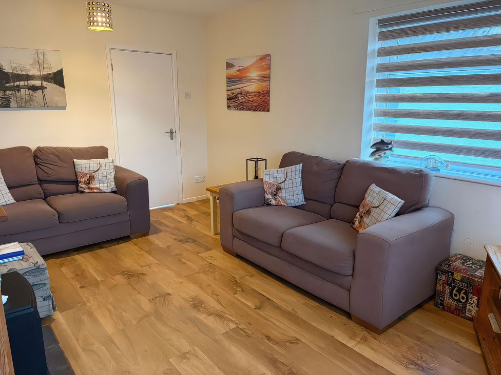 A living room with two sofas and wall art at Jacuma in Rhosneigr